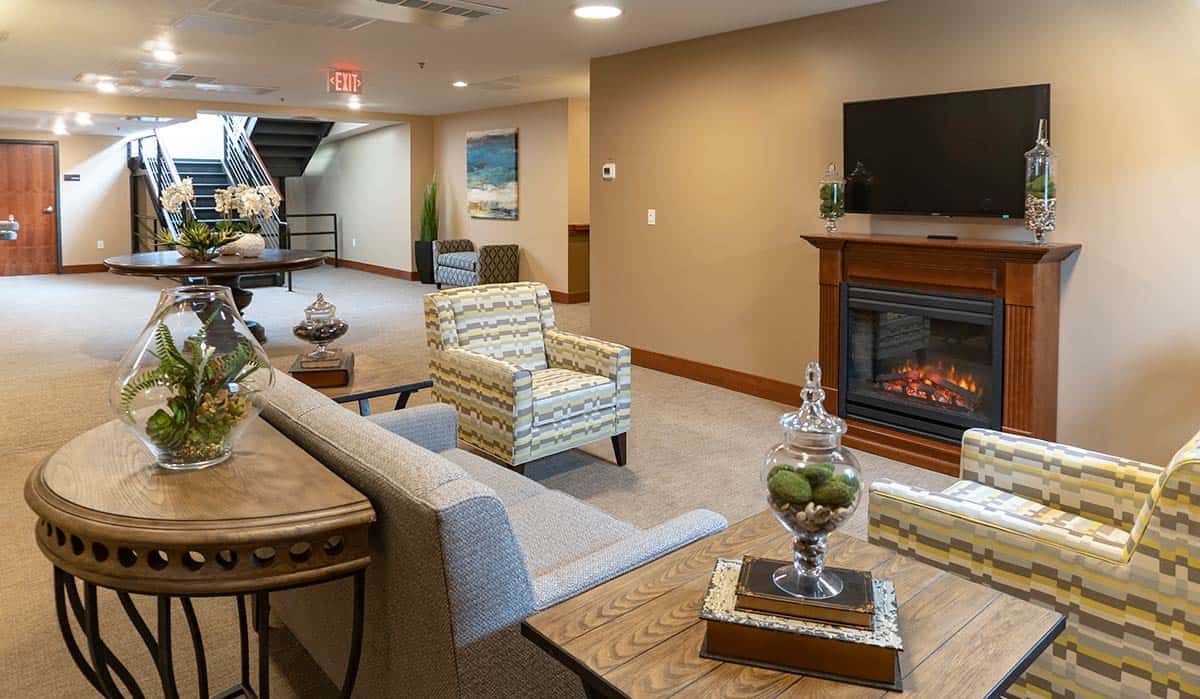 Interior view of Millers Landing senior living community featuring cozy living room with fireplace and TV.