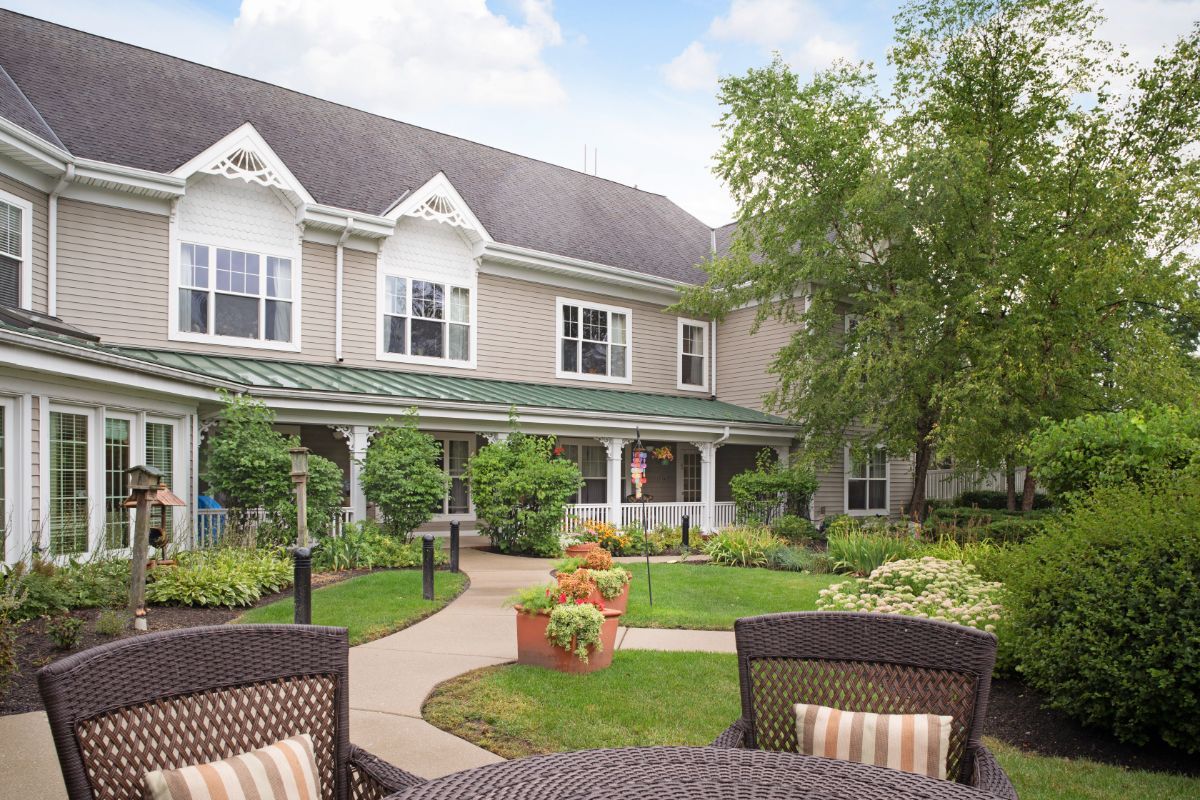 Senior living community, Sunrise of Buffalo Grove, featuring lush lawns, outdoor furniture, and modern architecture.