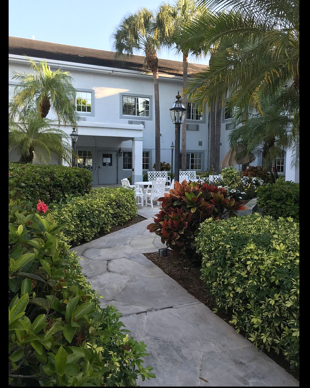 Pathway through the lush garden at Arden Courts senior living community in West Palm Beach.