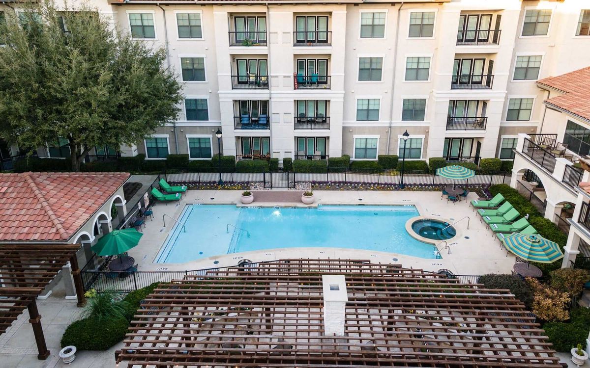 Aerial view of Conservatory At Plano senior living community with outdoor swimming pool and urban architecture.