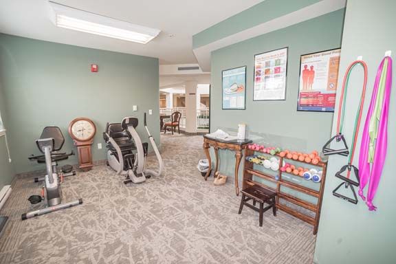 Senior resident working out in the gym at Rittenhouse Village Gahanna, with modern fitness equipment.