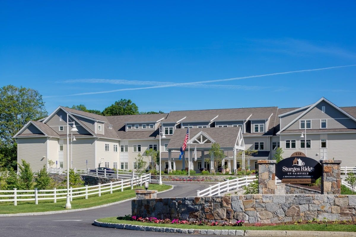Senior living community at Sturges Ridge of Fairfield with cars, flags, and residents.