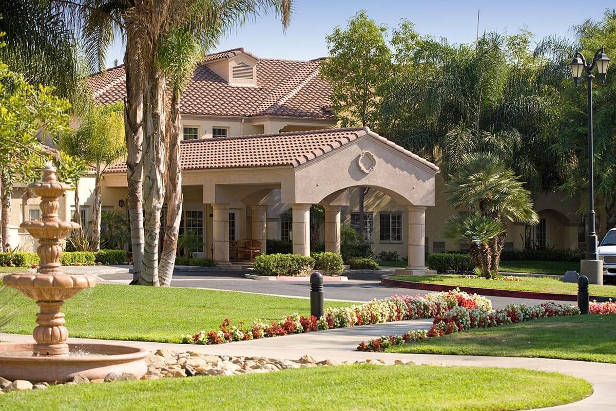 Park Terrace senior living community villa with lush greenery, portico, and waterfront view.