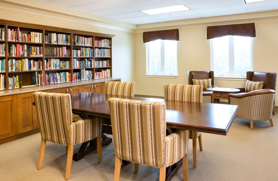 Interior view of Prairie Green at Dixie Crossing senior living community featuring a library and dining room.