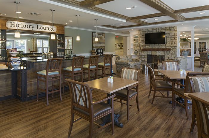 Interior view of Brightview Tenafly senior living community featuring a restaurant and café with hardwood flooring.