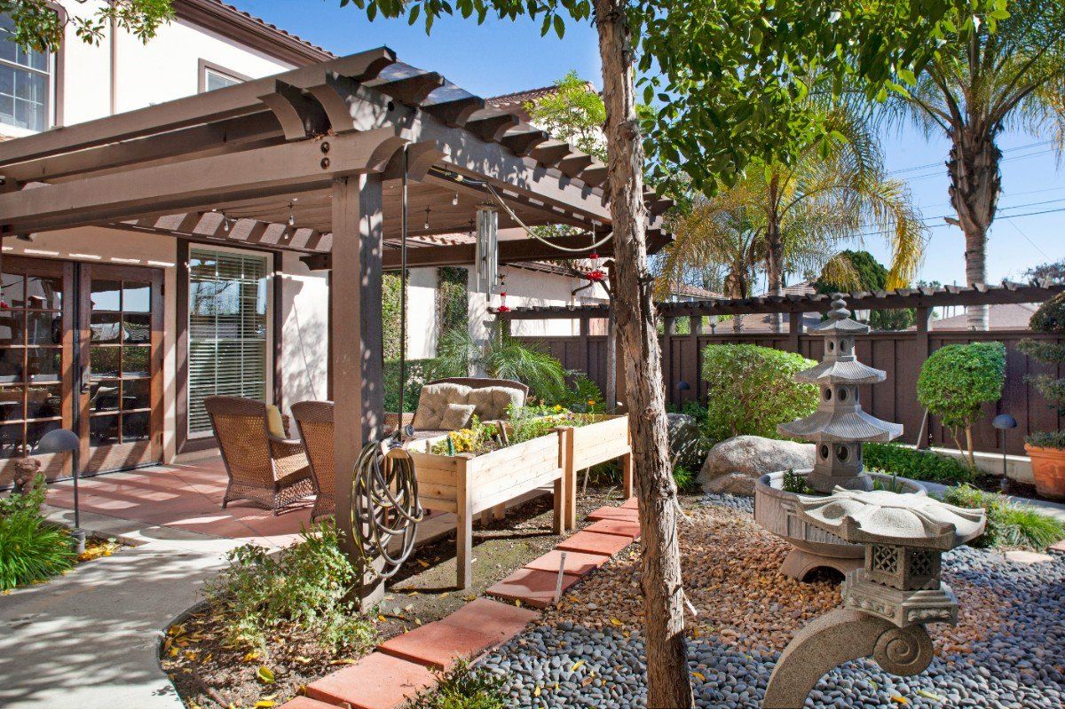 Senior living community Ivy Park at San Marino featuring houses with patios, pergolas, and garden.