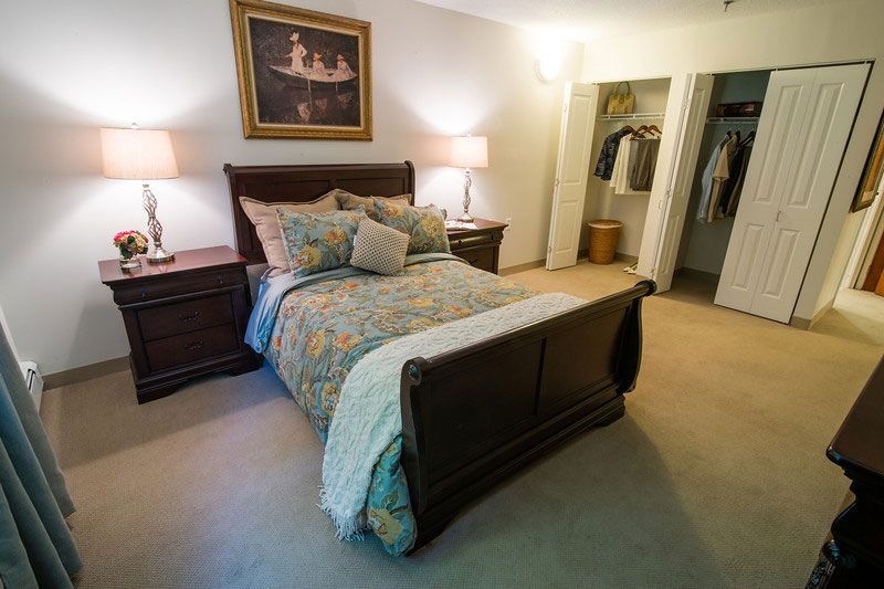 Senior living community bedroom interior with furniture, home decor, and personal accessories.