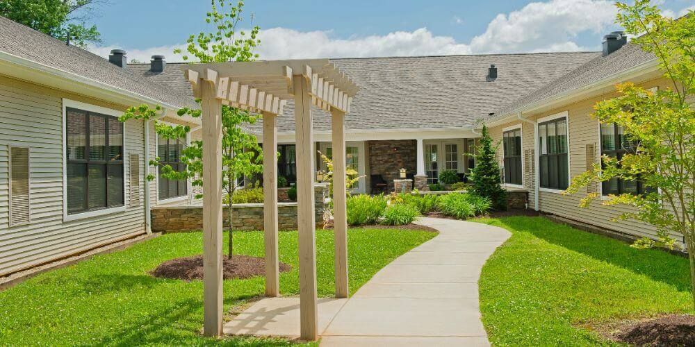 Senior living community Asbury Place Maryville featuring lush backyard, patio, and pergola.