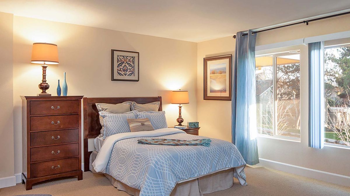 Interior design of a bedroom at Atria Walnut Creek senior living community with elegant furniture.