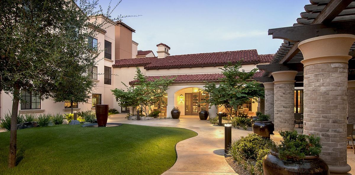 Maravilla Scottsdale senior living community villa with lush backyard and hacienda-style architecture.
