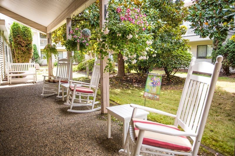 Senior living community, Summerfield Estates, featuring indoor and outdoor spaces with lush gardens and cozy furniture.