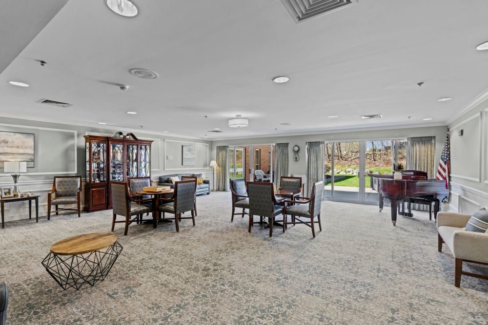 Senior living community in Chapel Hill featuring a piano, art-filled reception room, and dining area.