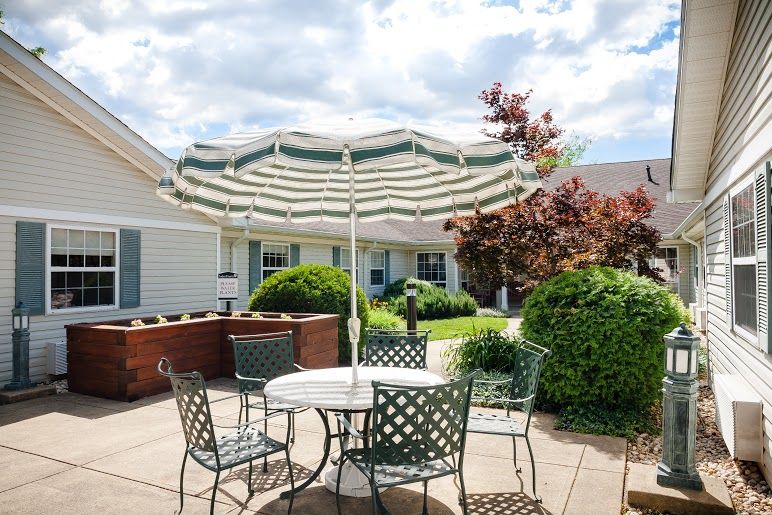 Backyard view of Arden Courts Of Silver Spring senior living community with patio furniture.