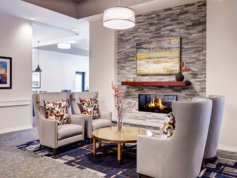 Interior view of Atria At River Trail senior living room with cozy fireplace and elegant home decor.