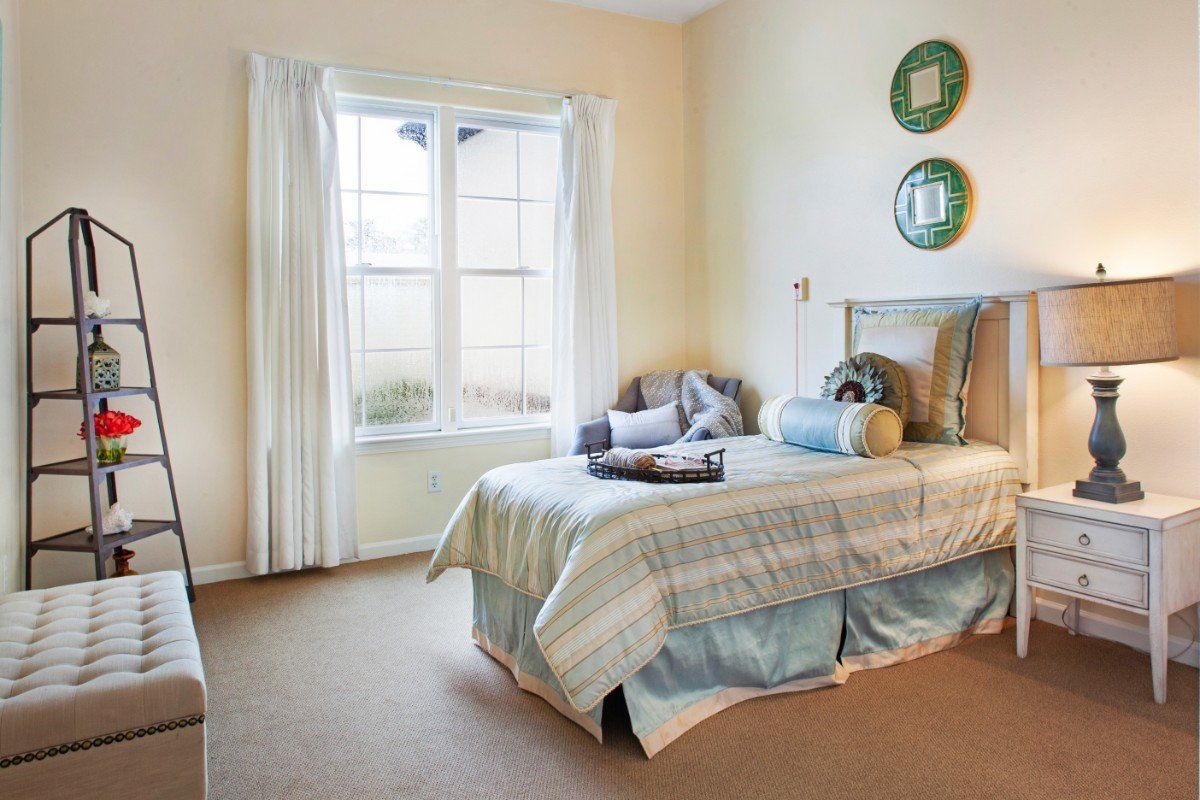 Interior view of a well-decorated bedroom at Ivy Park Senior Living Community in San Marino.