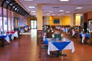 Indoor dining area with tables and chairs at Grand Court Lakes senior living community.