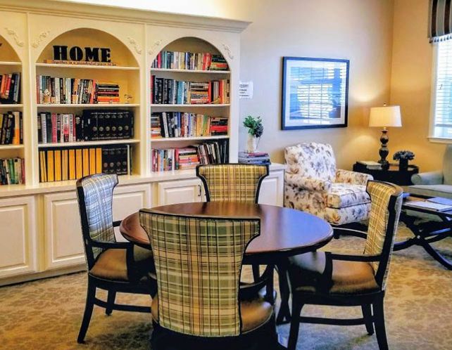 Senior living community Revere Court of South Barrington featuring dining room with table, chairs, bookcase and decor.