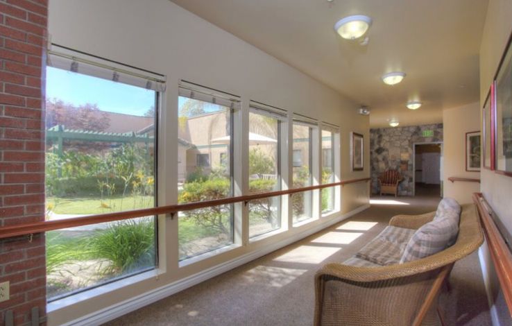 Interior view of Summerfield Memory Care Of Encinitas, showcasing living room with chair and window.