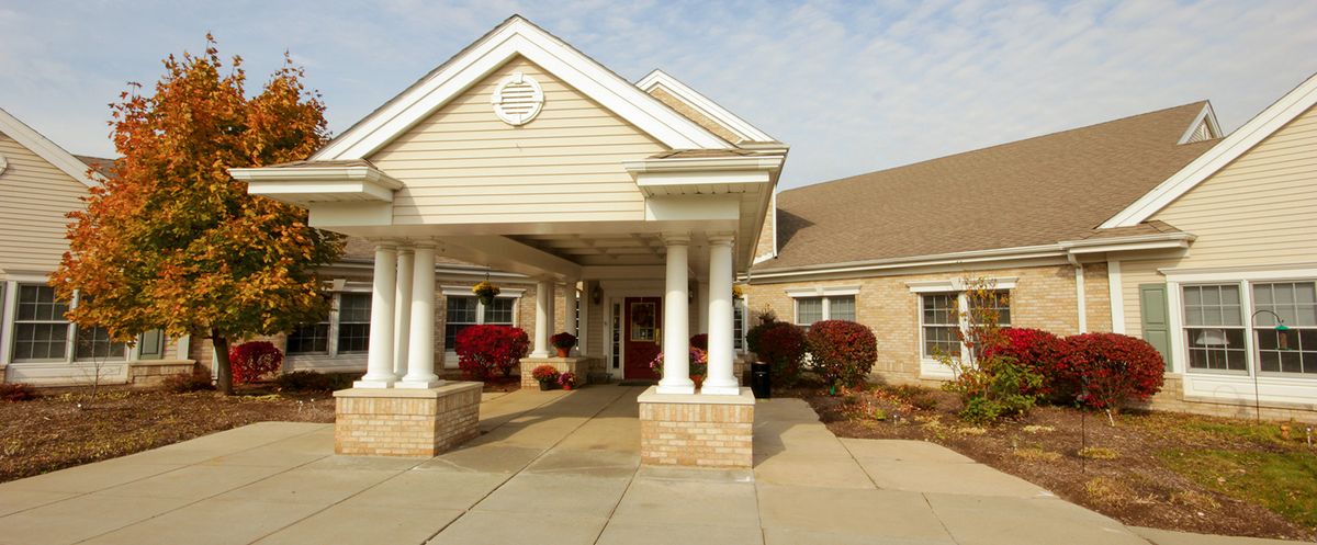 Architectural view of Brookdale Troy senior living community building with portico and plants.