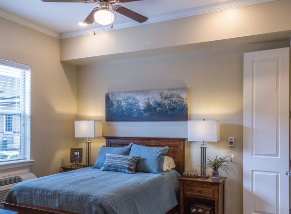 Interior design of a bedroom in Legacy At Crystal Falls senior living community with modern appliances and decor.