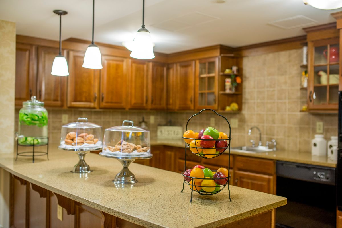 Interior view of Wentworth Senior Living kitchen with hardwood flooring, wooden shelves, and fresh produce.