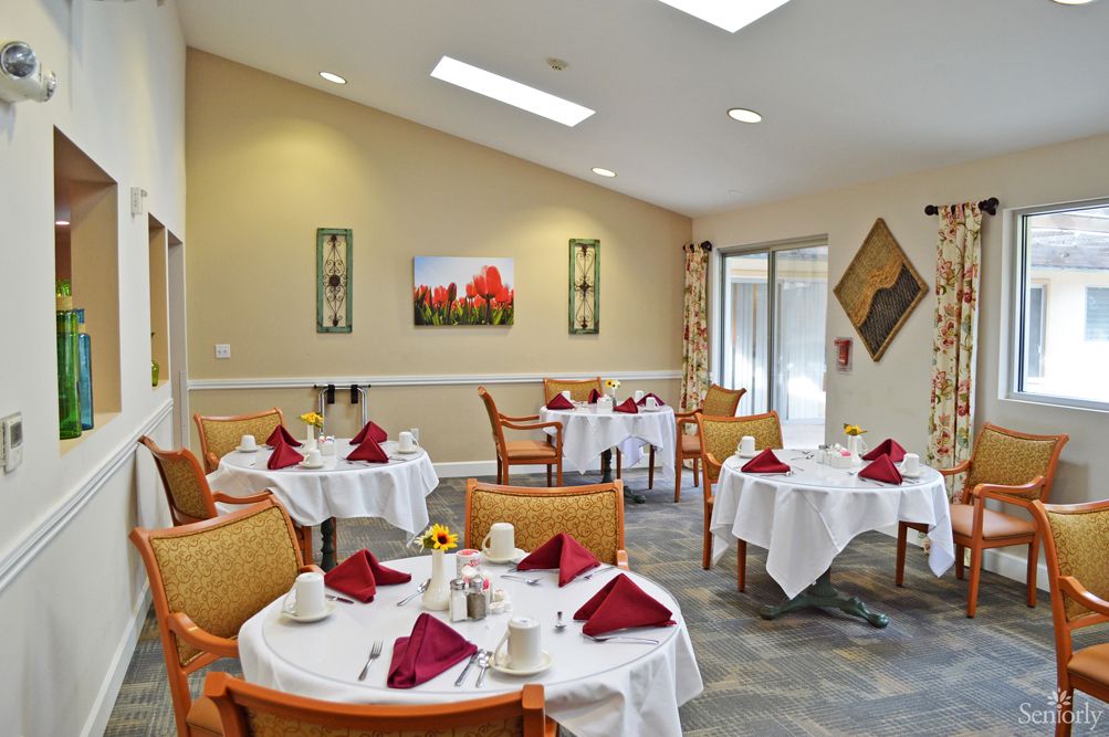 Dining room with furniture and tablecloth in TreVista at Concord senior living community.