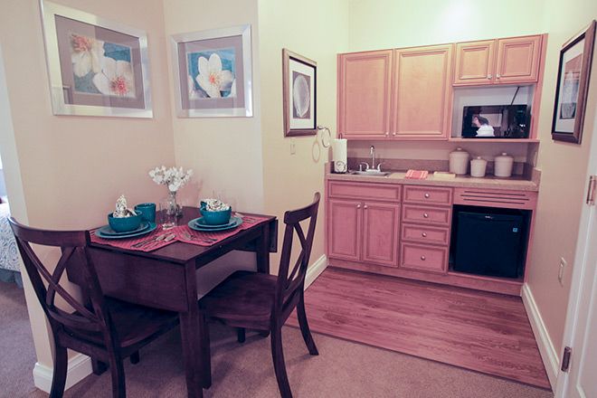 Interior view of Brookdale Port Charlotte senior living community featuring dining room, kitchen, and living room.