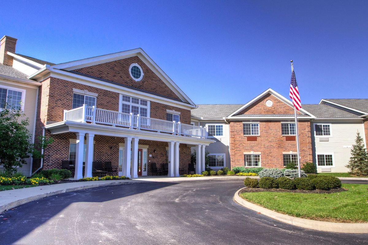 Senior living community in Long Cove with suburban houses, flag, road, and outdoor furniture.