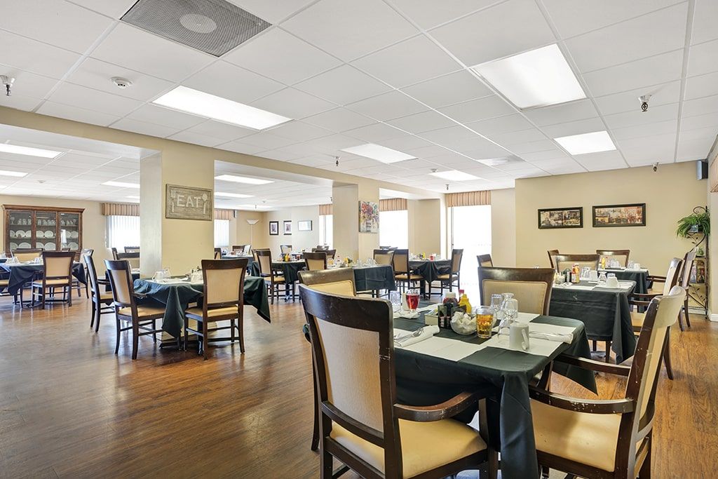 Interior view of Arbor Palms senior living community in Anaheim featuring dining area, art, and lounge.