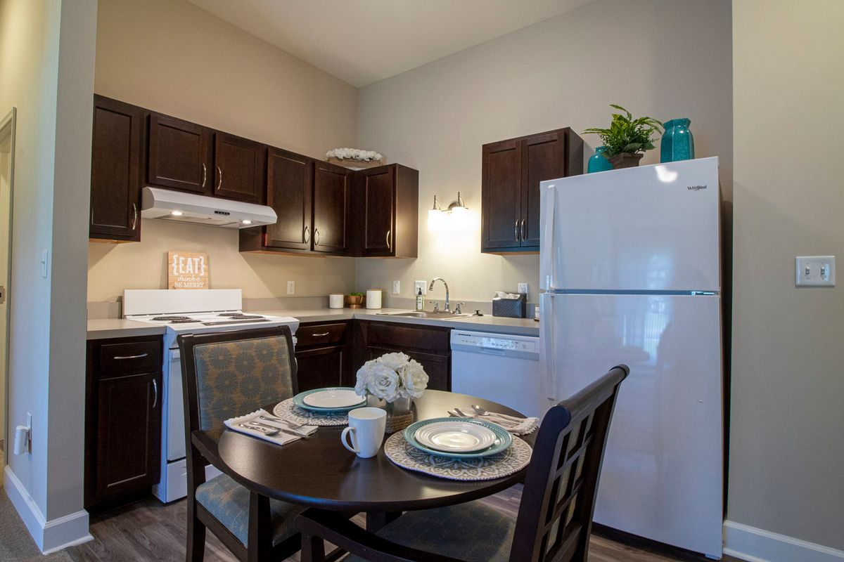 Interior view of Storypoint Libertyville senior living community featuring dining room, kitchen appliances, and home decor.