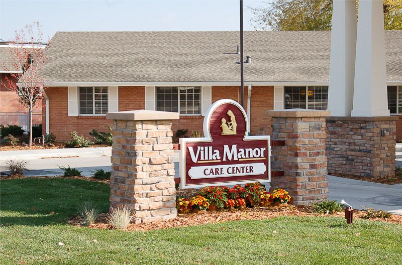 Senior living community, Villa Manor Care Center, featuring brick architecture and lush vegetation.