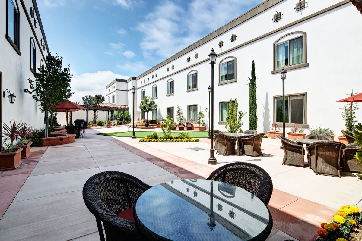 Senior living community Clearwater At South Bay featuring villa-style housing, patio furniture, and city views.