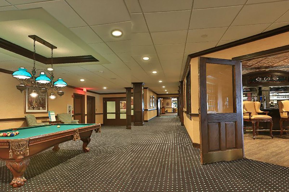 Interior view of Brandywine Living at Voorhees featuring a billiard room with pool table and chairs.