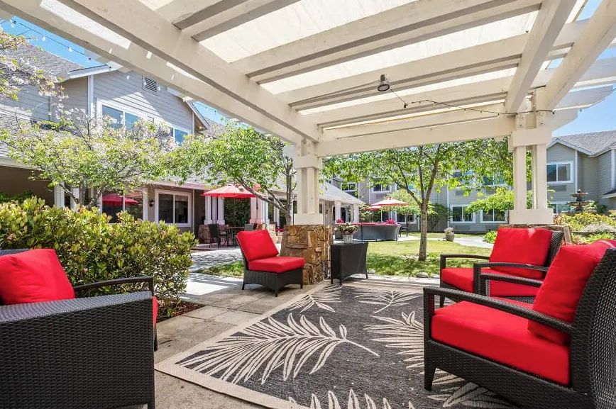Interior and exterior view of Aegis Living Greenwood, showcasing architecture, furniture, and nature.