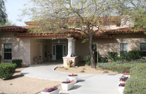 Senior living community Barton House showcasing its architectural villa-style building with a patio and plants.