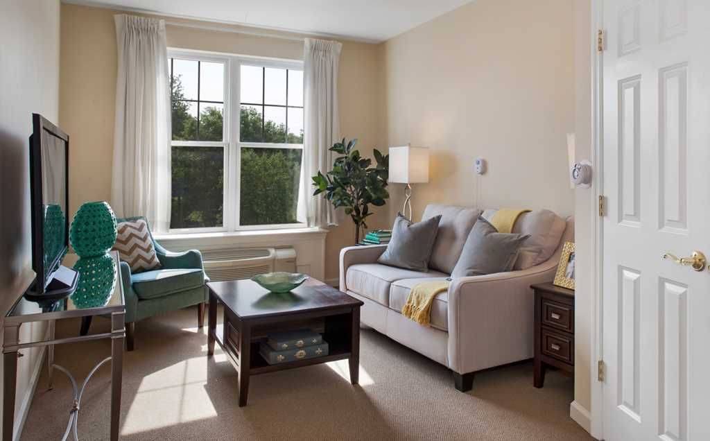 Interior view of Fairmont Senior Living on Clayton featuring modern decor, furniture, and electronics.