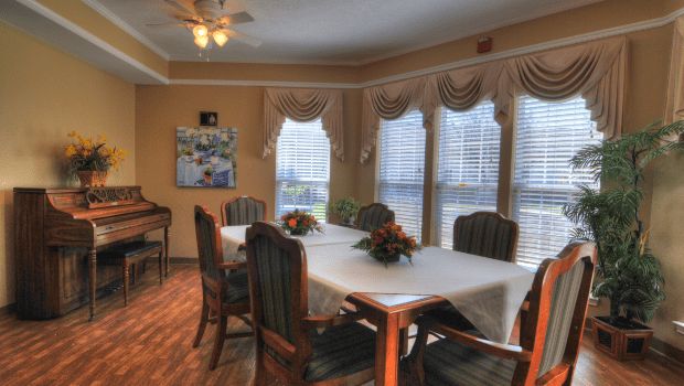 Interior view of Charter Senior Living of Gallatin featuring dining area, piano, and elegant decor.