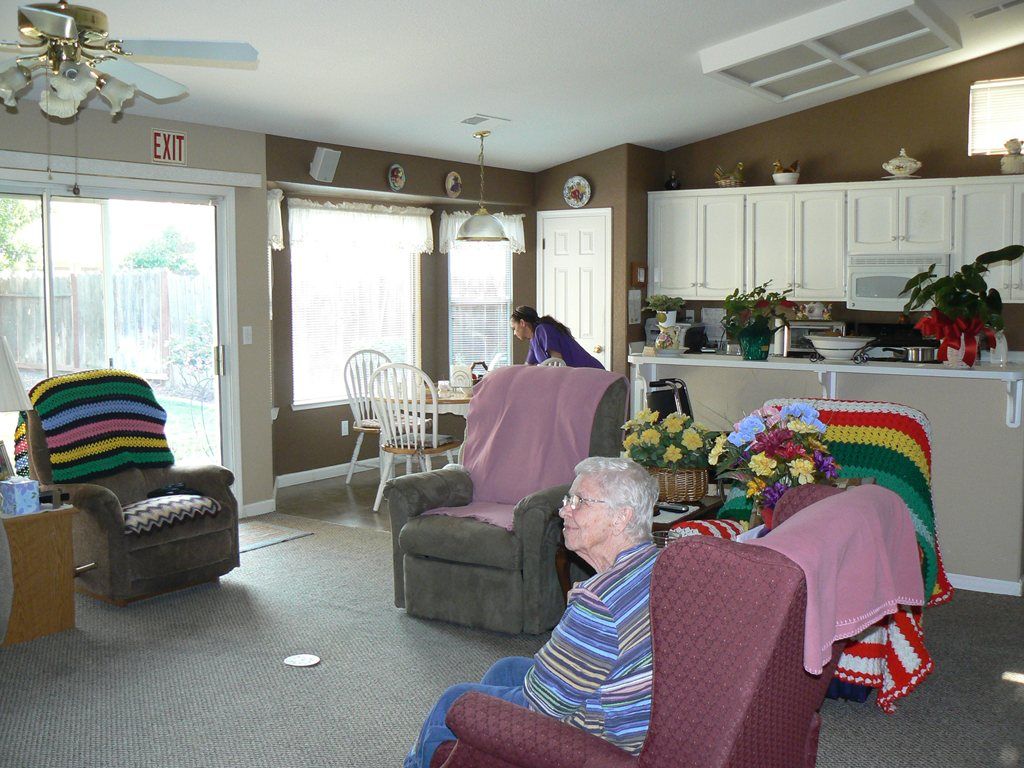 Senior man relaxing in a well-furnished living room at Guardian Angel Home Care II community.