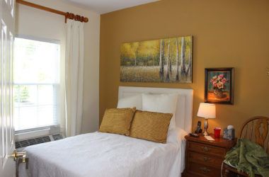 Comfortable bedroom interior at Carrick Glen Senior Living with cozy decor and furniture.