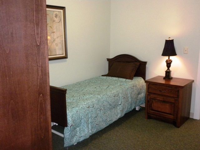 Interior view of a cozy bedroom at Provident Memory Care Center with elegant furniture and art.