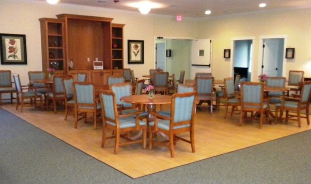 Interior of Provident Memory Care Center featuring dining area, reception desk with computer, and art decor.