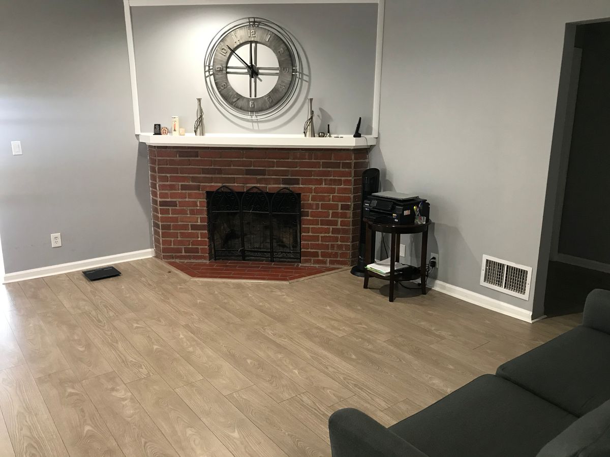Senior living community room featuring interior design with fireplace, hardwood flooring, and electronics.