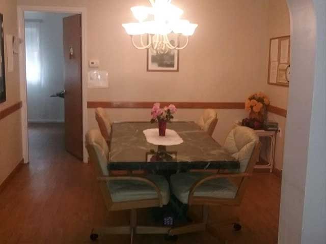 Interior view of Croton Manor senior living community featuring dining room with elegant furniture and art.