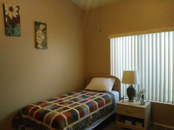Senior resident relaxing in a well-furnished room at Rhodas Assisted Living Home with cozy decor.