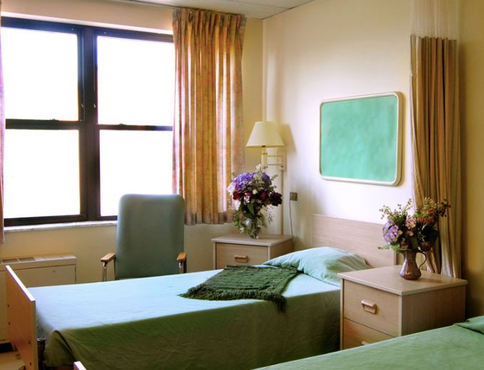 Senior living community bedroom at Princeton Rehab & Health Care Center with floral decor.