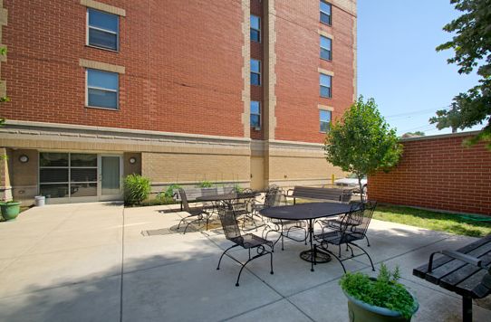 Senior Suites Bridgeport, an urban senior living community with outdoor patio, yard, and high-rise condos.