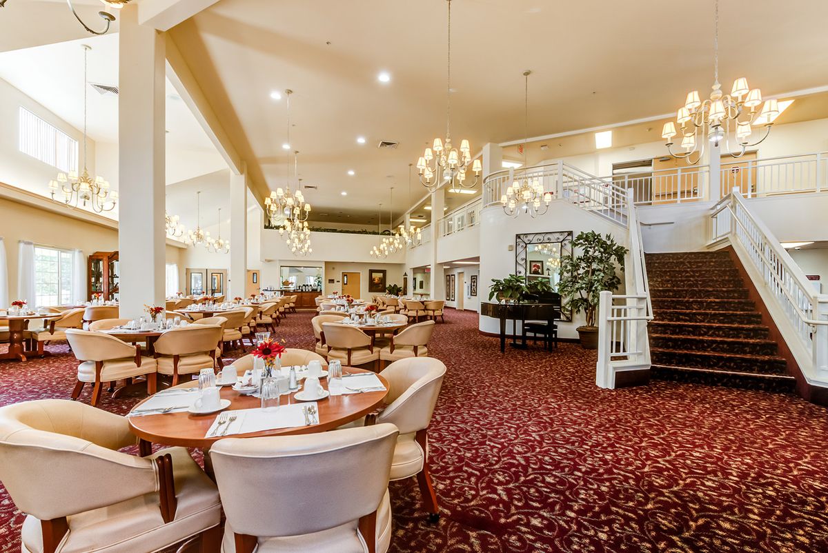 Indoor view of The Palms At Bonaventure Senior Living with dining area, staircase, and lounge.
