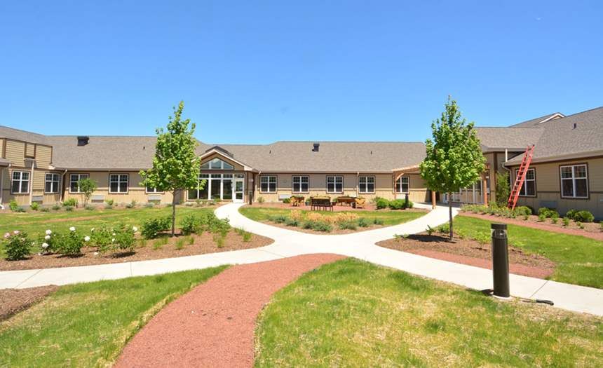 Senior living community, Silverado St. Charles, featuring lush greenery and modern architecture.