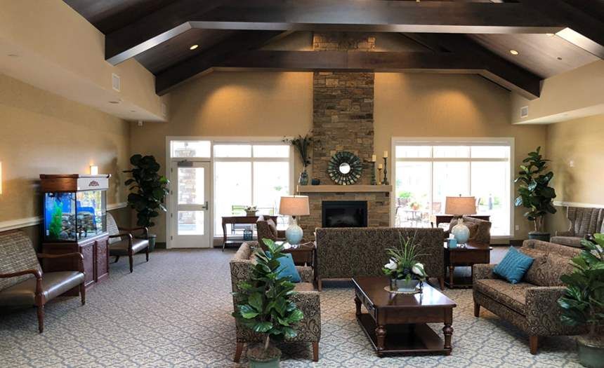 Senior living room at Silverado St. Charles with cozy furniture, plants, and modern electronics.