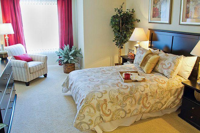 Senior living room at Brookdale Loma Linda with cozy furniture, bed, chair, and home decor.